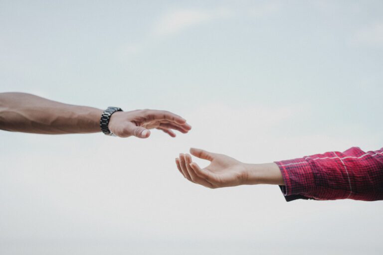 Two hands reaching towards each other, symbolizing connection and support.